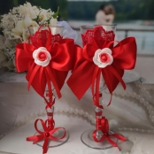 красные бокалы на свадьбу с бантами и розами